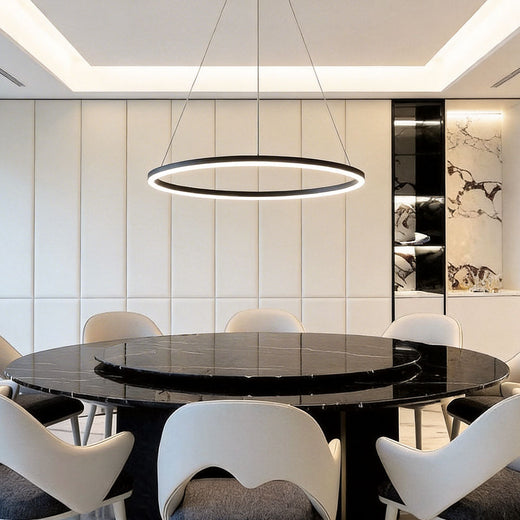 Minimalist black LED ring chandelier over a luxury black marble dining table with white chairs.