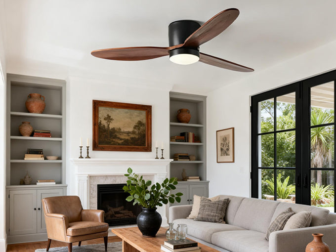 Modern wood ceiling fan with light installed in a bright living room with neutral furniture and large windows.