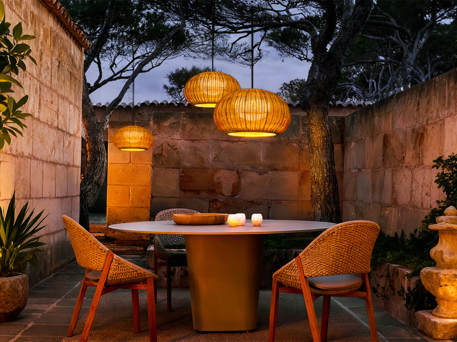 Cozy outdoor dining setup illuminated by warm rattan lanterns in a natural garden setting.