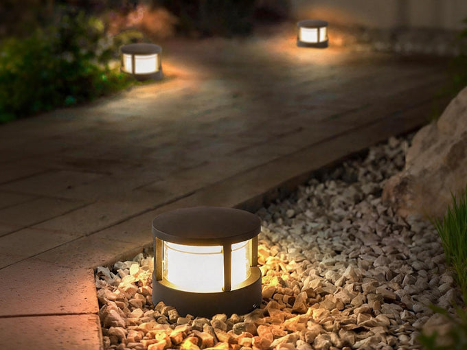Low profile outdoor LED bollard lights illuminating a garden pathway at night