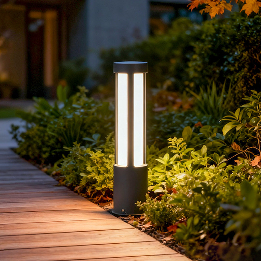 Residential bollard lights used along a wooden deck walkway, highlighting the tall linear design with warm light for exterior spaces.