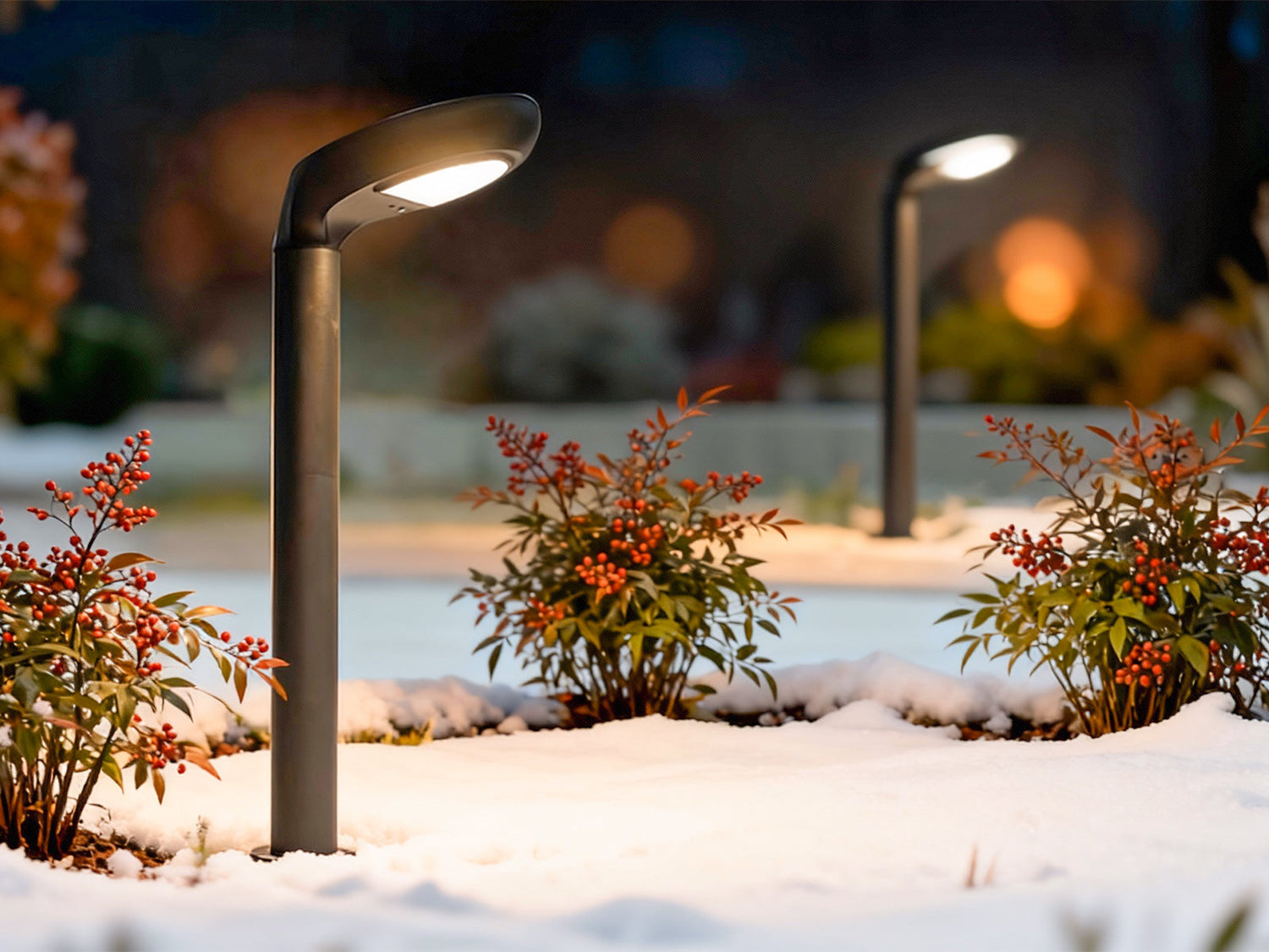 Outdoor solar lights glowing in a snowy garden at night.