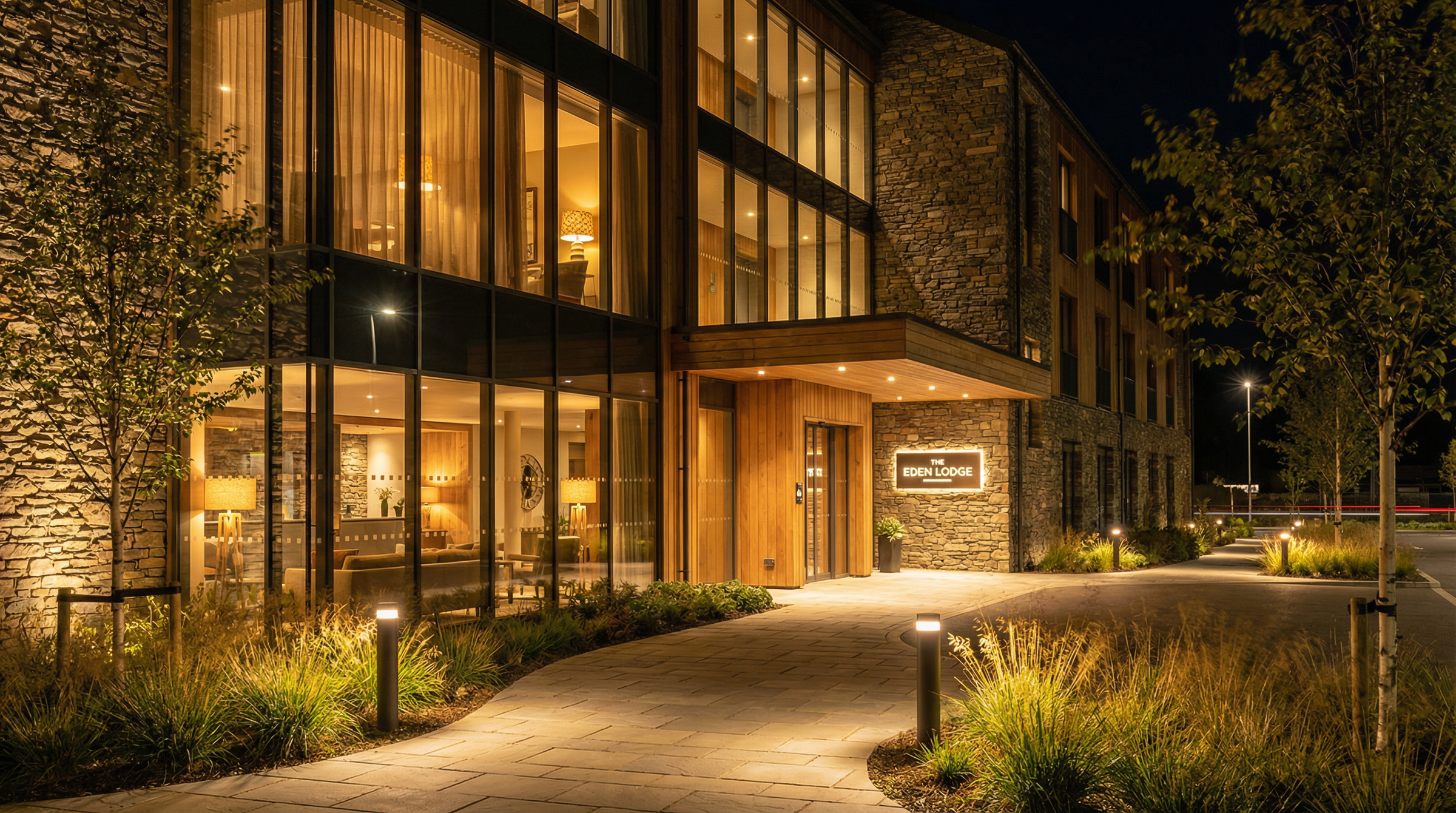 Hotel exterior with pathway bollards and warm facade lighting, showing nighttime arrival visibility and curb appeal