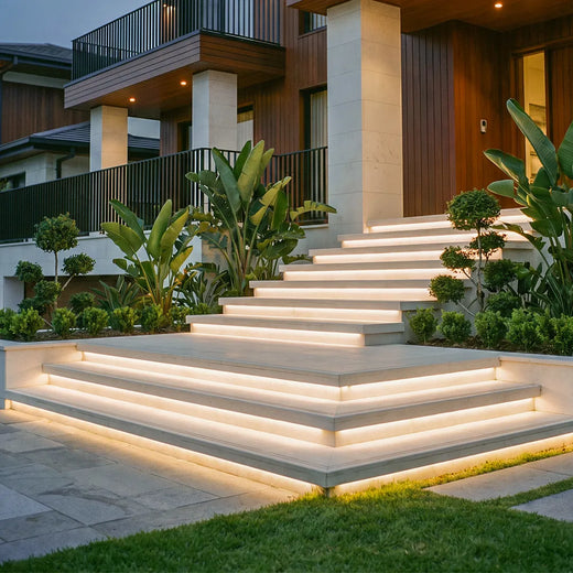 Outdoor embedded LED light strips integrated into modern entry stairs, providing warm accent lighting along each step edge.