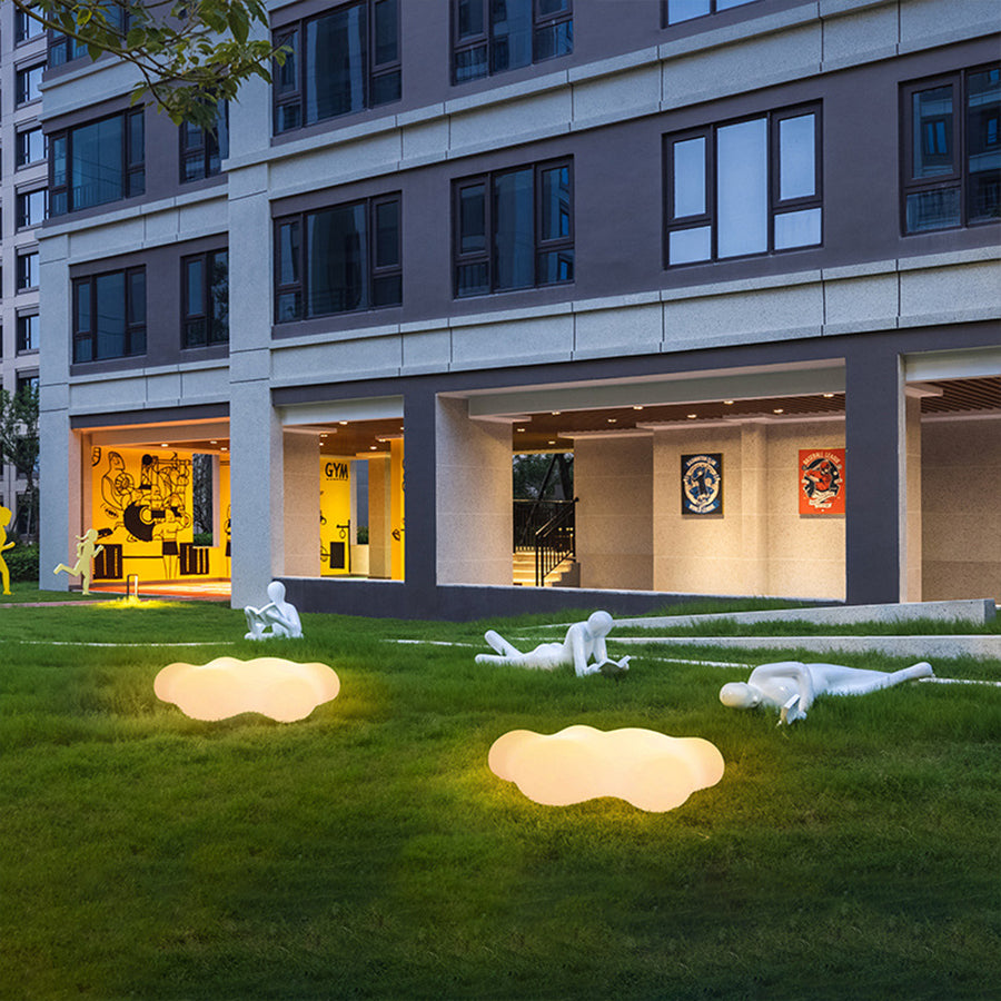 Modern residential complex with glowing cloud-shaped landscape lighting on grass areas