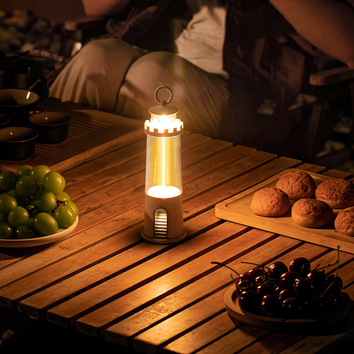 Compact portable lamp with Edison bulb illuminating wooden deck surface in outdoor setting