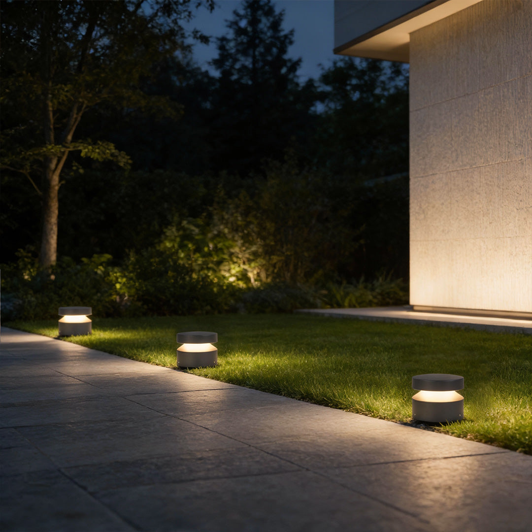 Minimalist 110v landscape lights placed along a modern yard edge, providing balanced light distribution at night.