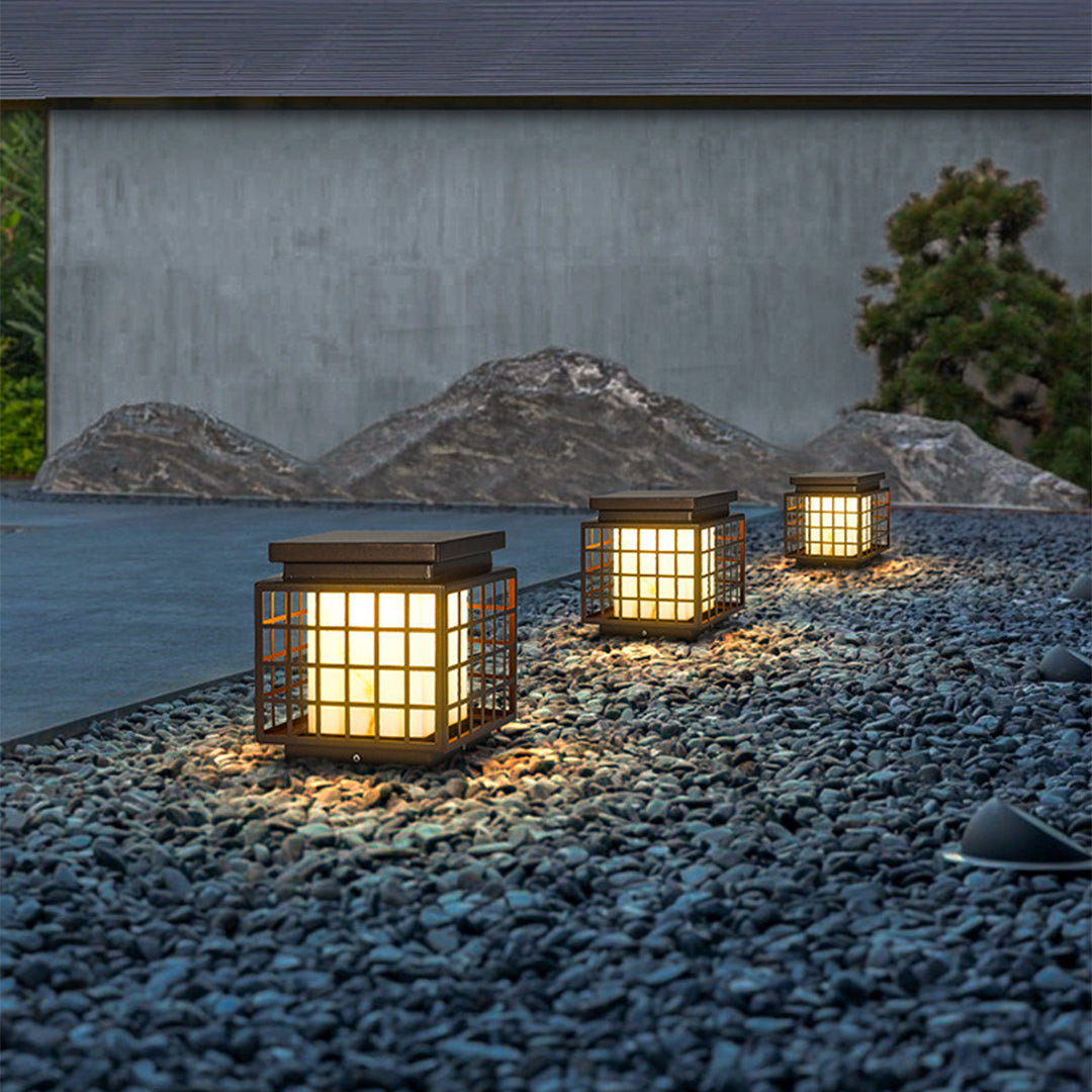 Japanese-style solar lanterns placed on stone surface creating peaceful zen garden atmosphere with natural rock elements