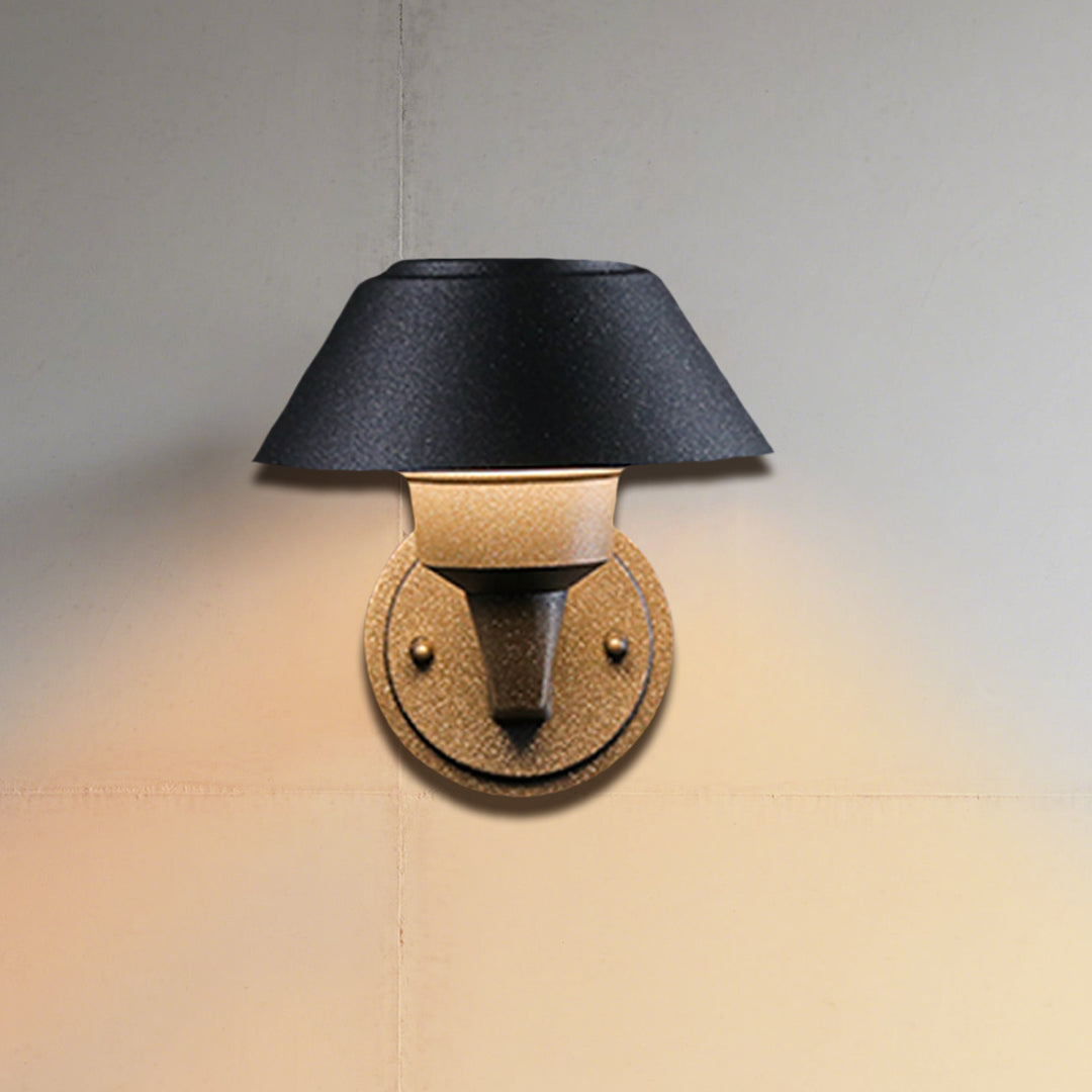 Modern black dome wall light with extending arm illuminating brick exterior wall at dusk