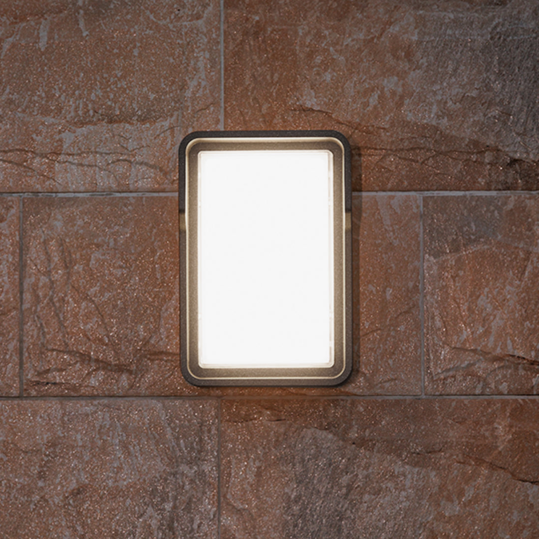 Contemporary outdoor wall light with horizontal slats mounted on building exterior fence area