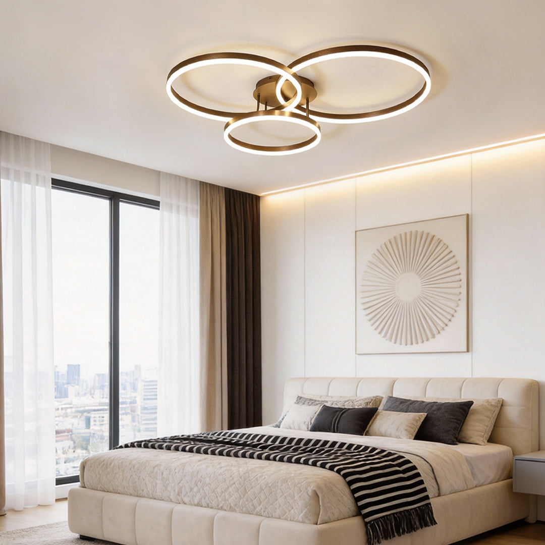 3 ring LED ceiling light providing soft light above a contemporary bedroom.