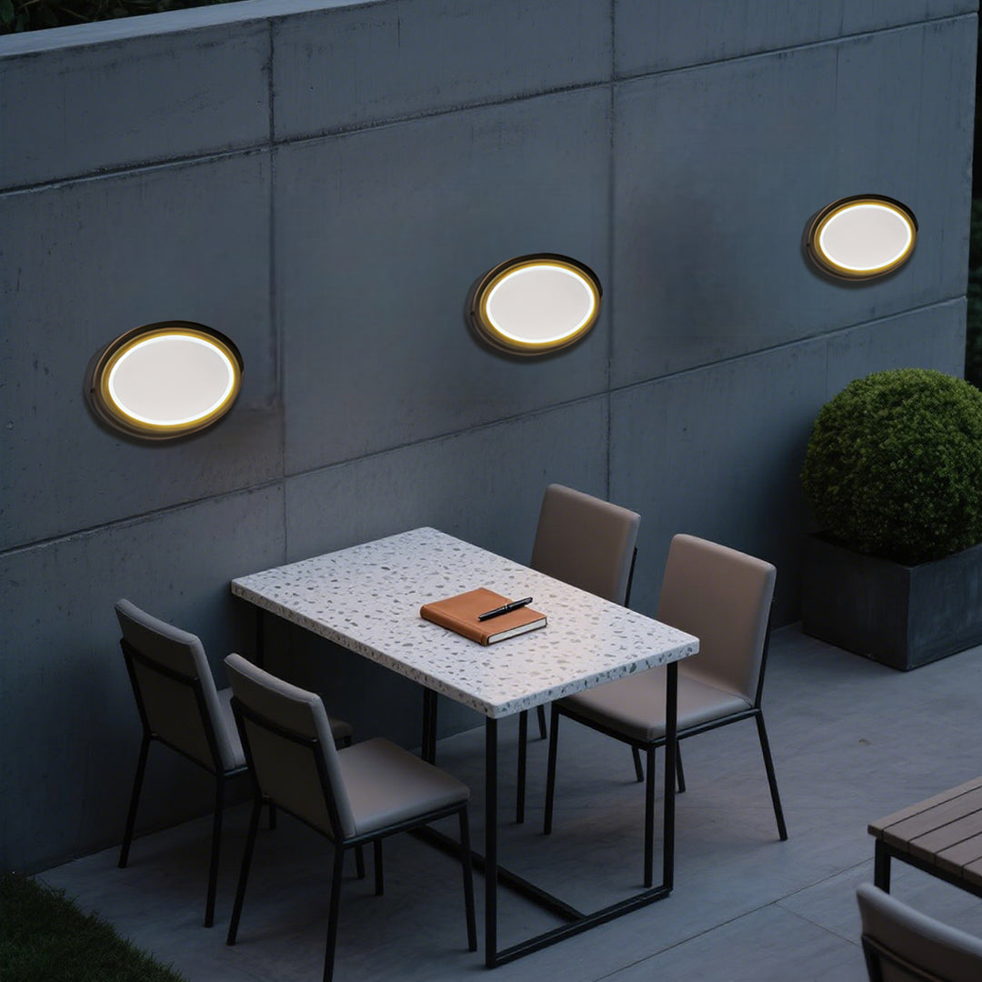 Round outdoor wall sconce with frosted diffuser creating ambient lighting on building exterior