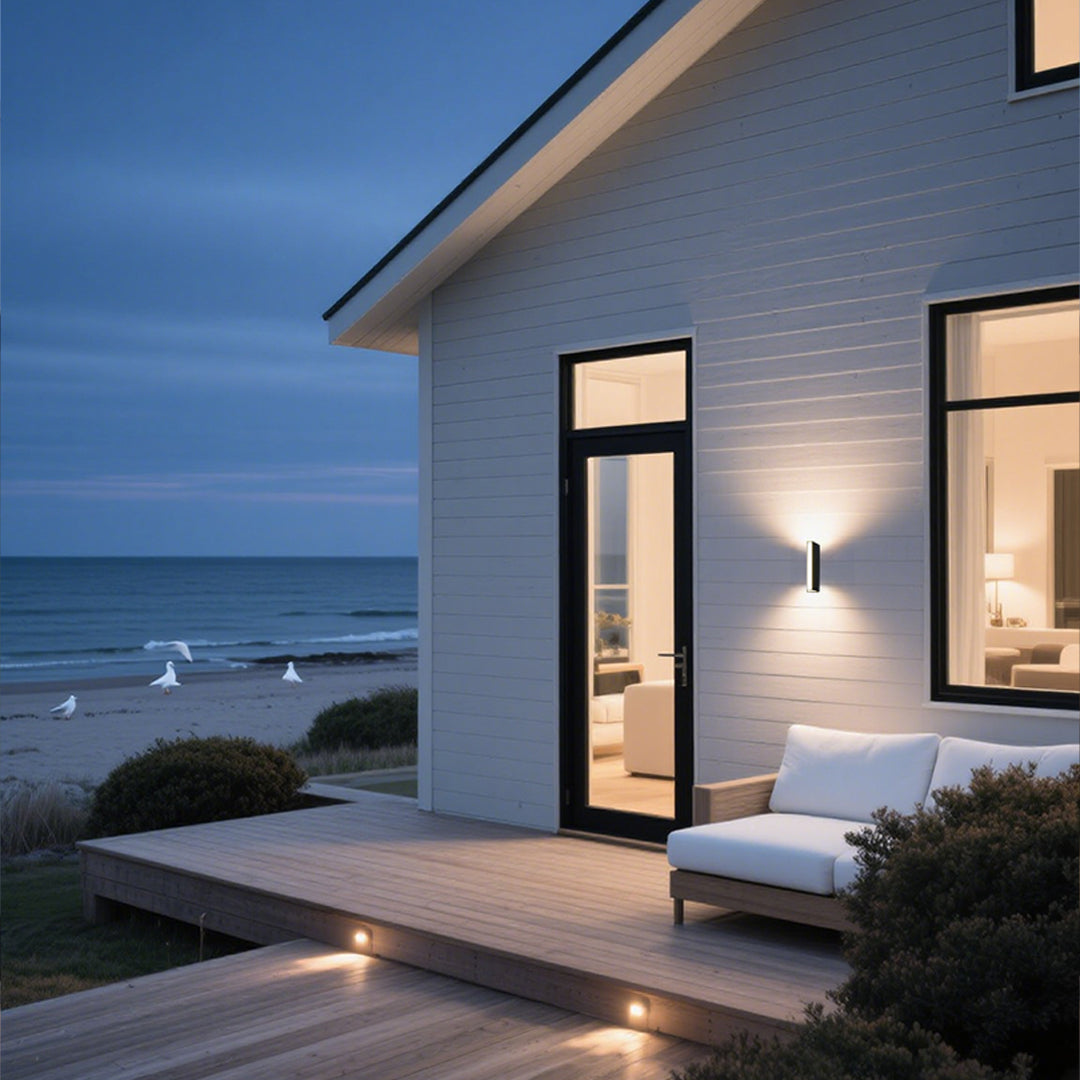 Vertical LED wall sconce mounted on textured stone exterior creating ambient lighting