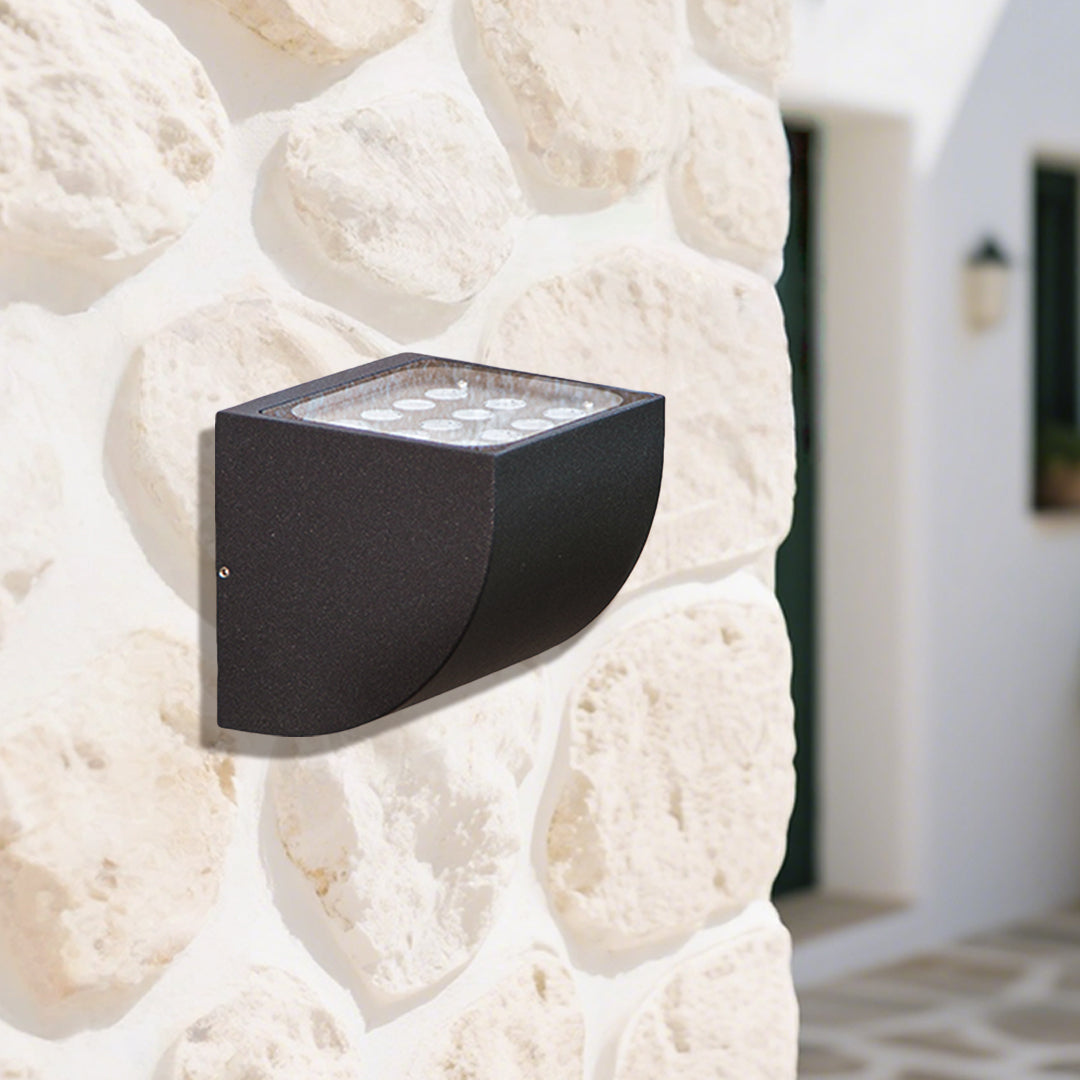 Close-up view of bronze outdoor light fixture showing curved arm and mounting details