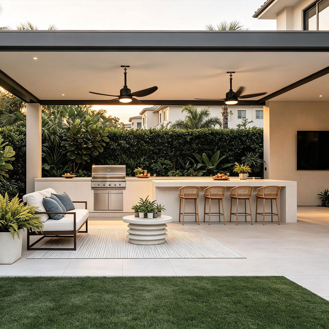 42 inch black ceiling fan with light cooling a modern outdoor kitchen and covered entertainment area.