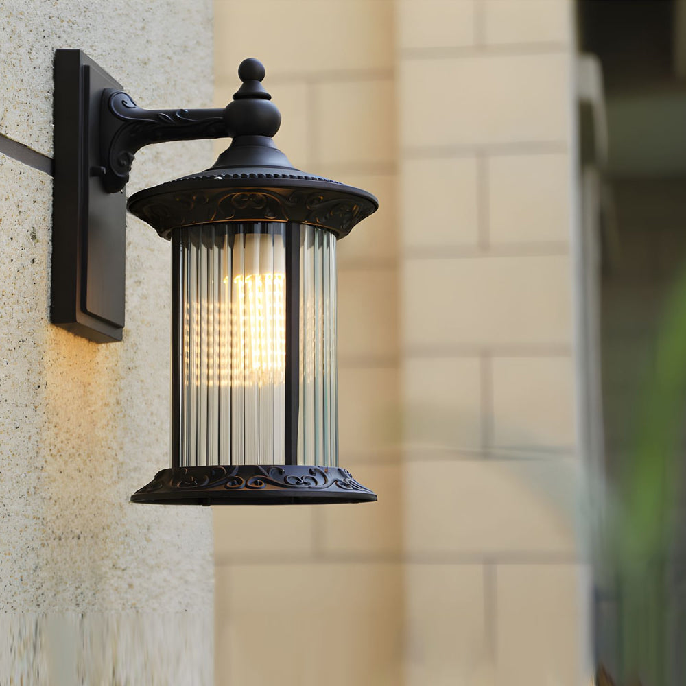 Heritage style outdoor wall light with ribbed glass diffuser mounted on textured stone exterior wall