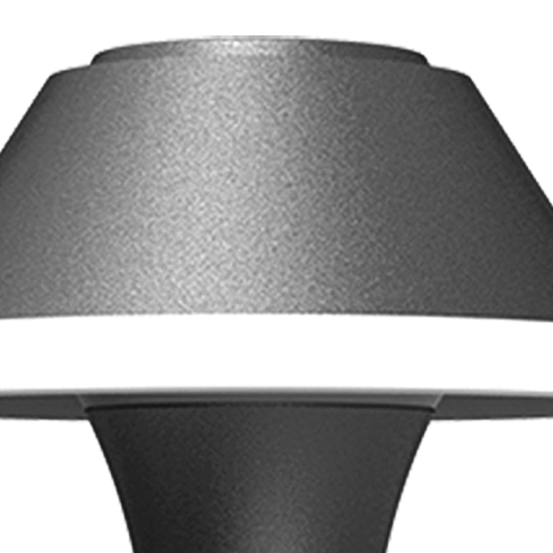 Contemporary outdoor wall sconce with conical shade casting warm light on white siding