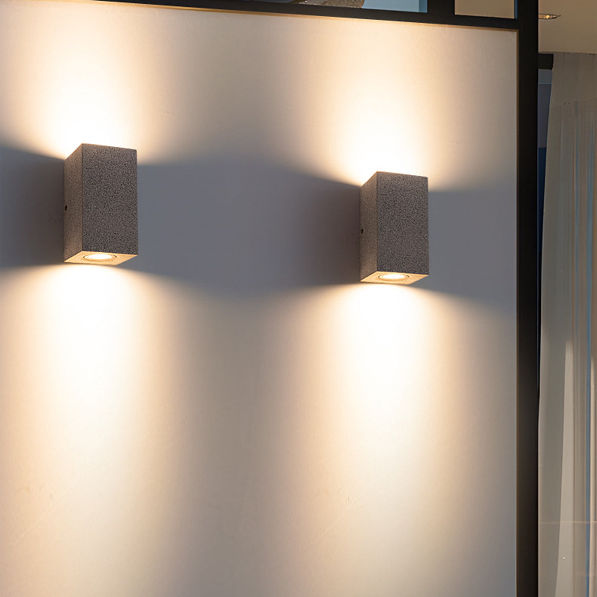 Professional installation of concrete wall lights creating dramatic up-down lighting effects indoors