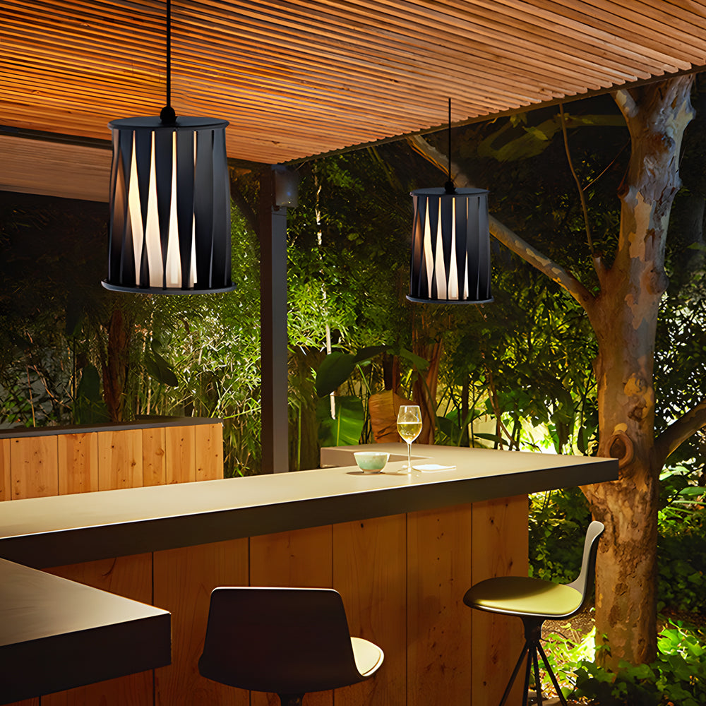 Outdoor dining area with suspended cylindrical lights illuminating wooden kitchen island under pergola