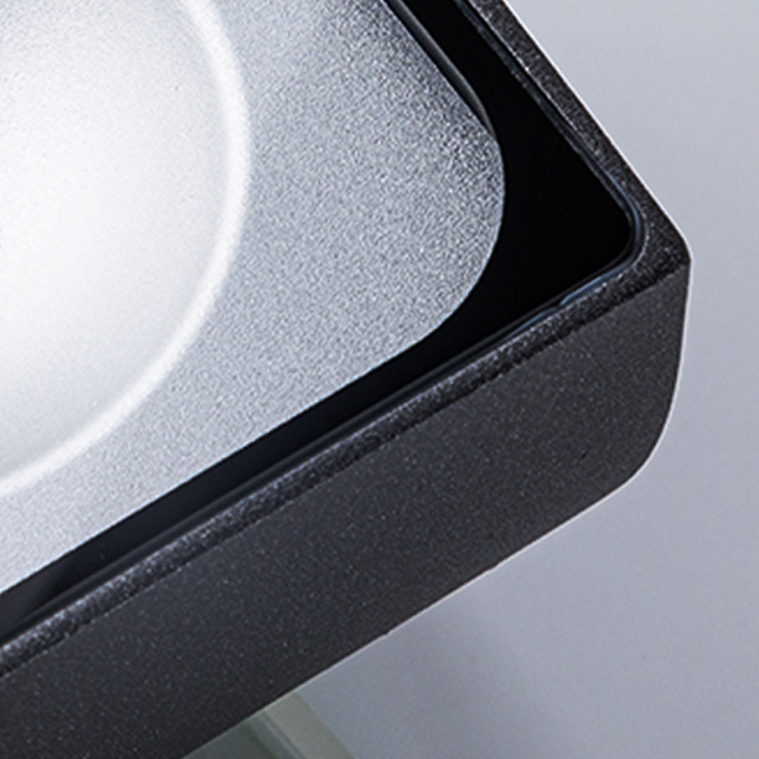 Traditional brass wall lantern with frosted glass shade mounted on stone exterior wall