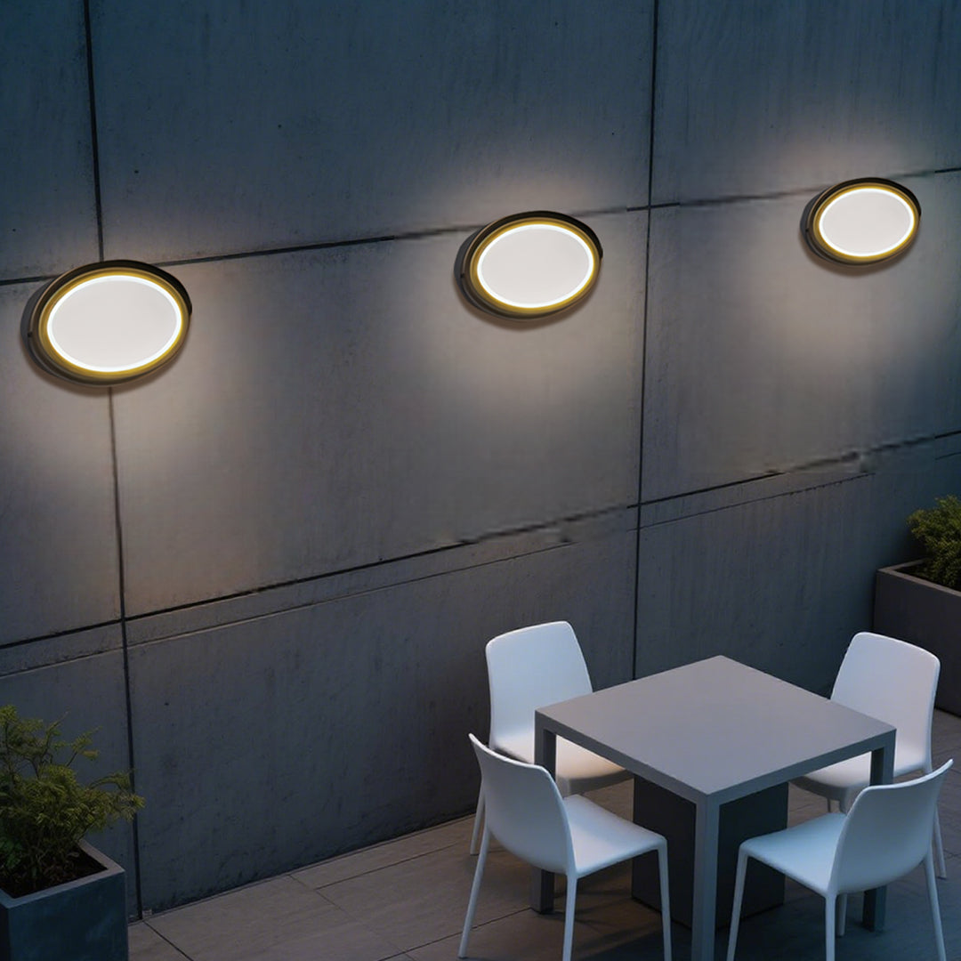 Round outdoor wall sconce with frosted diffuser creating ambient lighting on building exterior