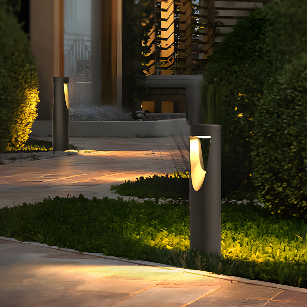 Modern residential walkway illuminated by stylish cylindrical pathway lights with warm glow