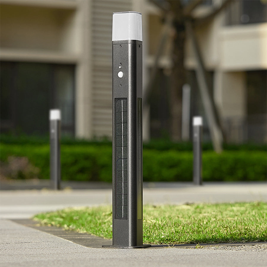 Tall solar pathway light with clean geometric design positioned along stone garden border