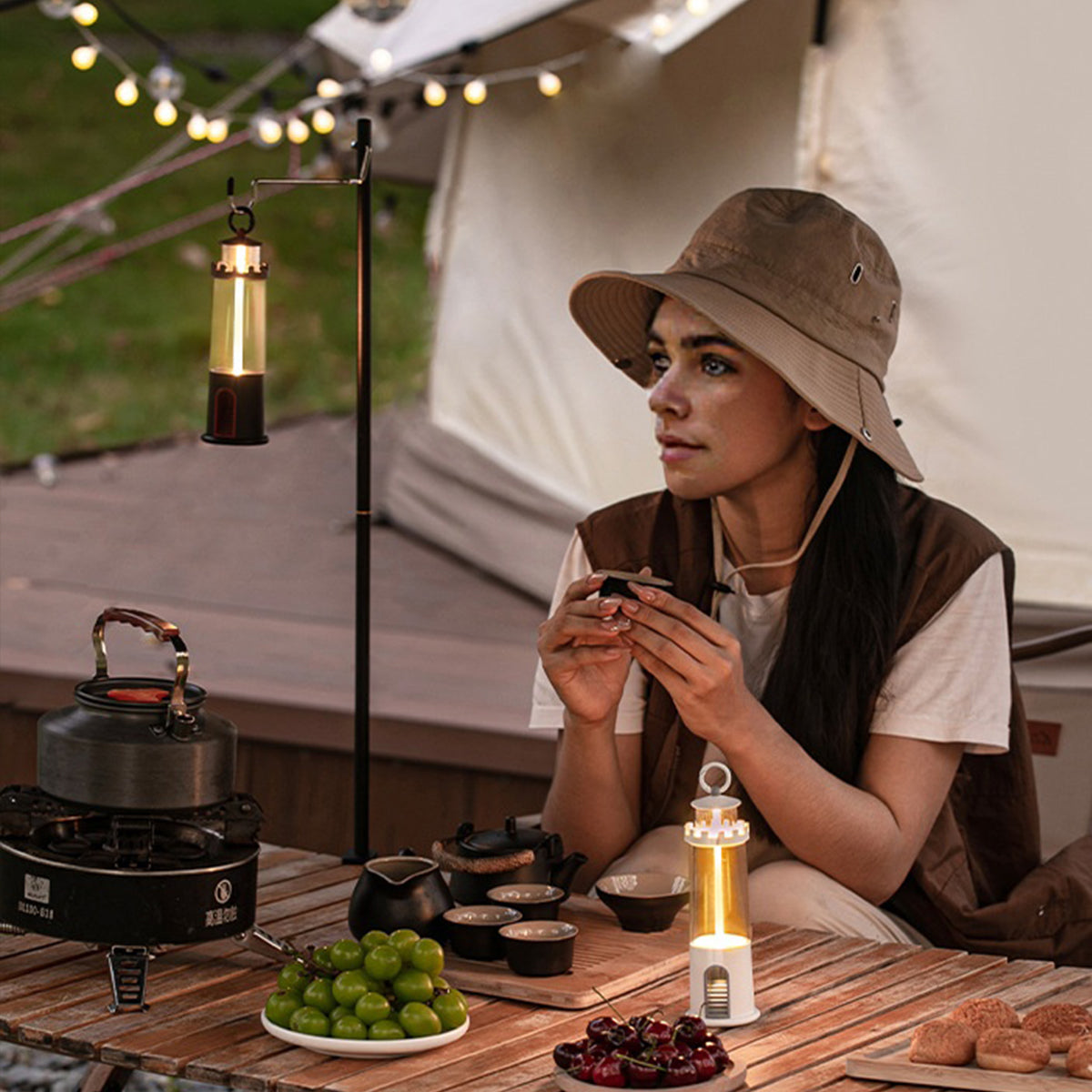 Woman enjoying outdoor dining with portable cylindrical table lamp providing warm ambient lighting