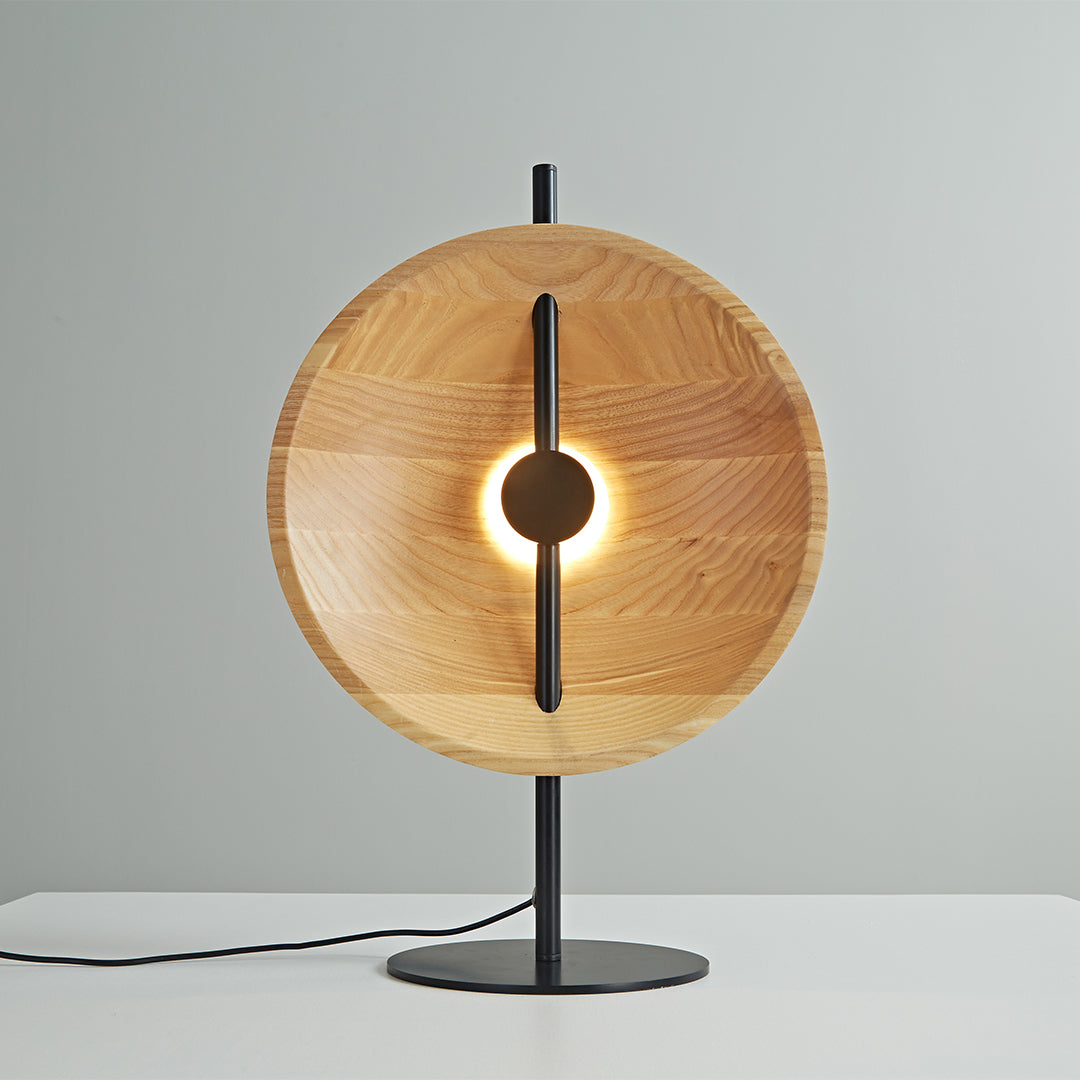 Featuring a unique round disc reflector, this wood modern table lamp provides stylish illumination and a refined aesthetic perfect for modern living spaces.