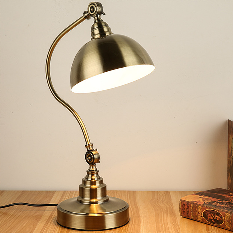 A classic copper table lamp with an adjustable body on a side table.