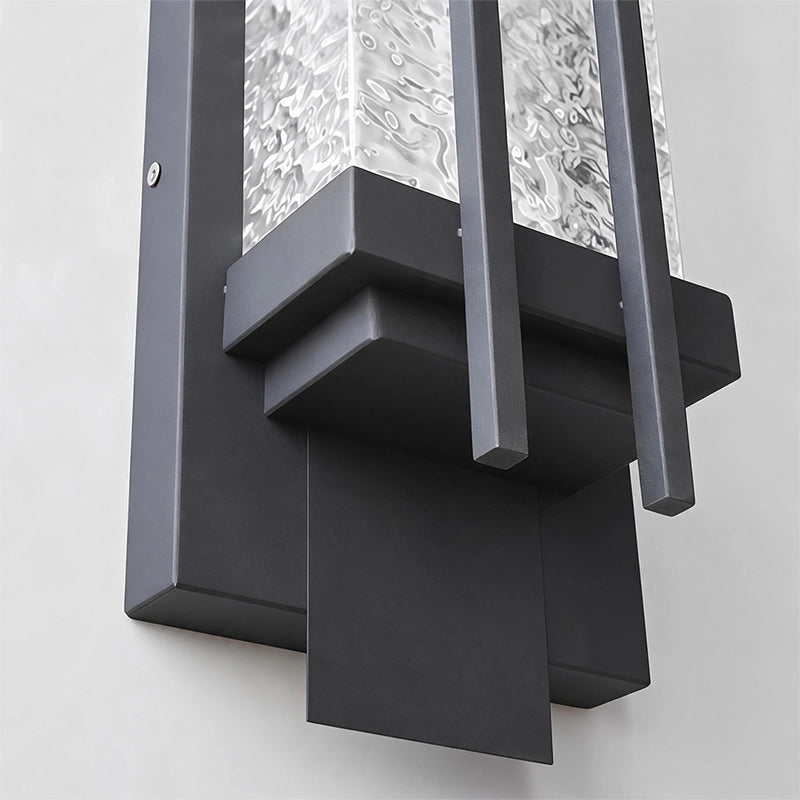 Black outside wall lights close-up showing the layered metal frame and textured glass construction.