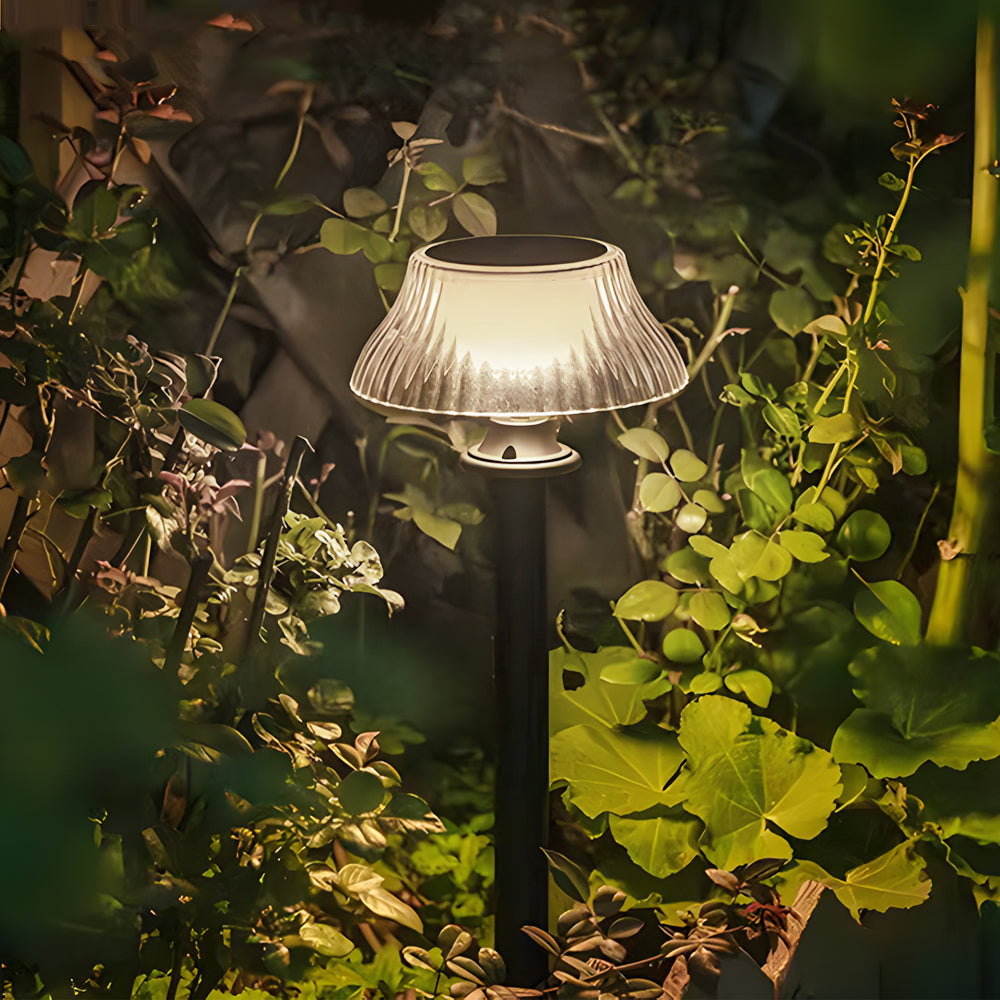 Solar pathway light glowing softly among autumn foliage and natural garden vegetation at dusk