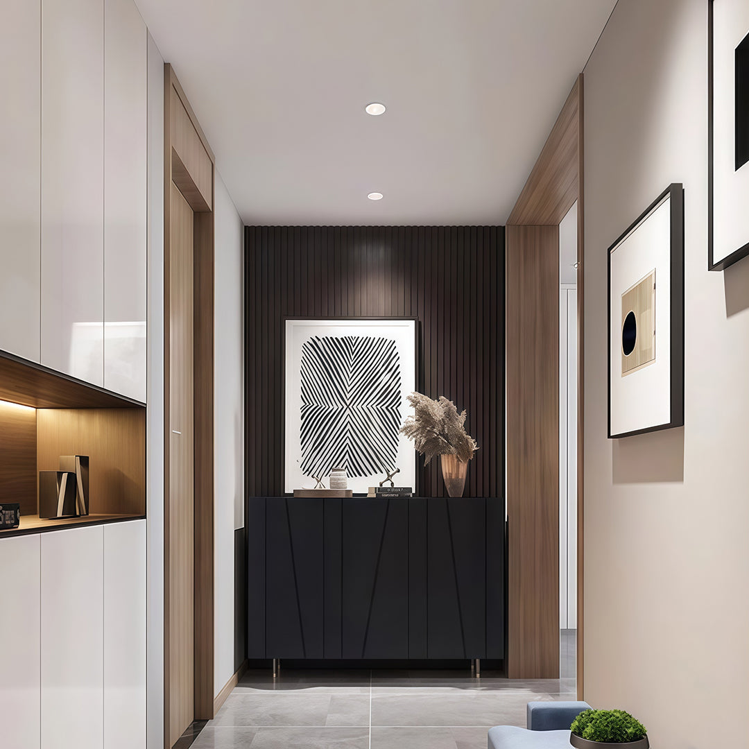 Accent spotlights enhancing modern entryway with dark accent wall and gallery-style artwork