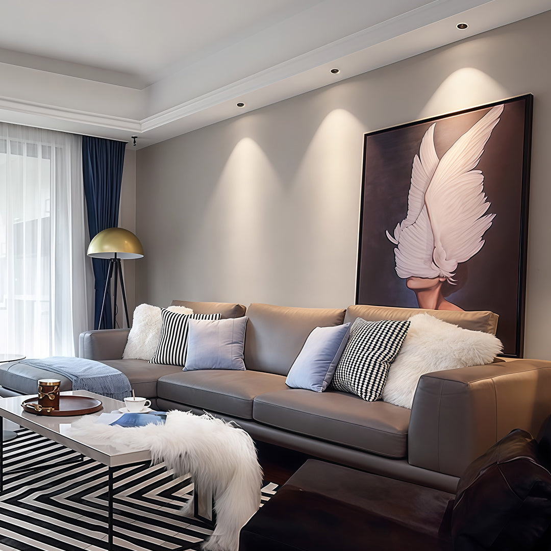 Adjustable downlights accenting modern bedroom with grey upholstered headboard and pink artwork