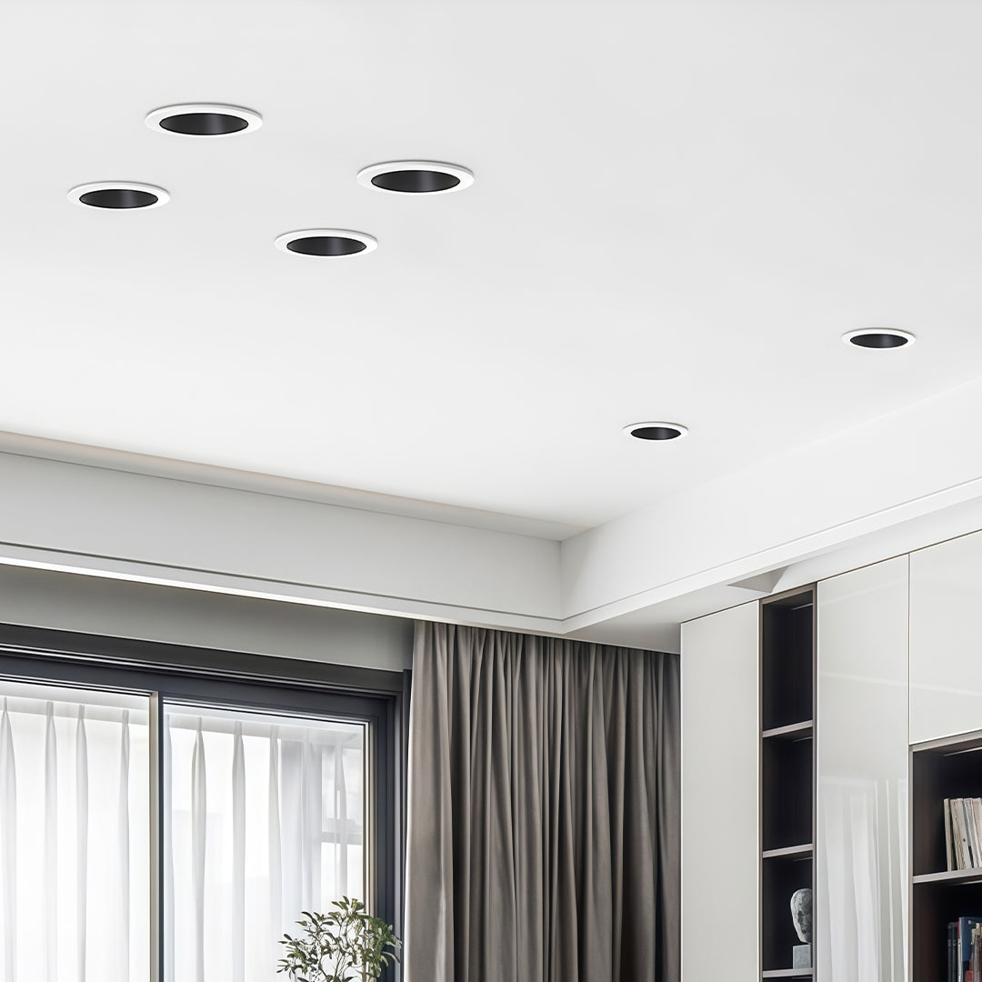 Adjustable downlights creating layered lighting in elegant room with grey curtains and modern decor
