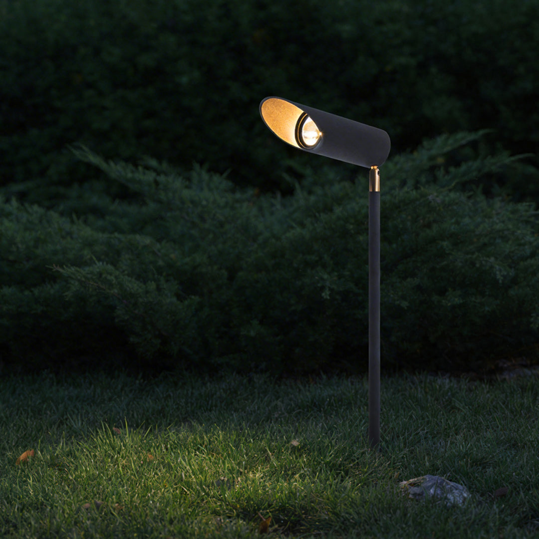 Adjustable landscape lighting enhancing a lush green lawn with warm directional light.