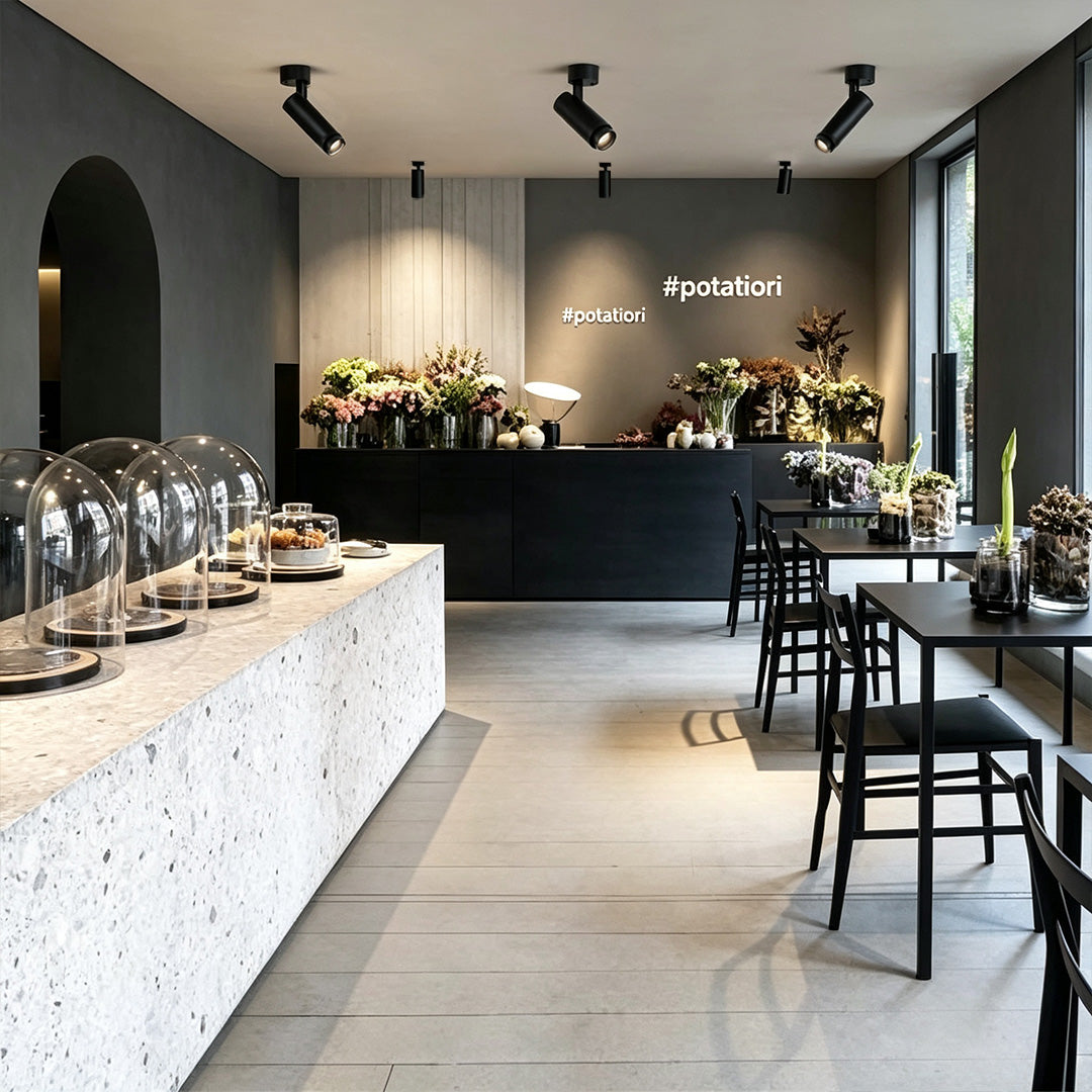 Black adjustable LED can lights installed above a contemporary café counter with directional spotlight design.