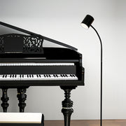 Adjustable tall floor lamps positioned next to piano creating perfect task lighting