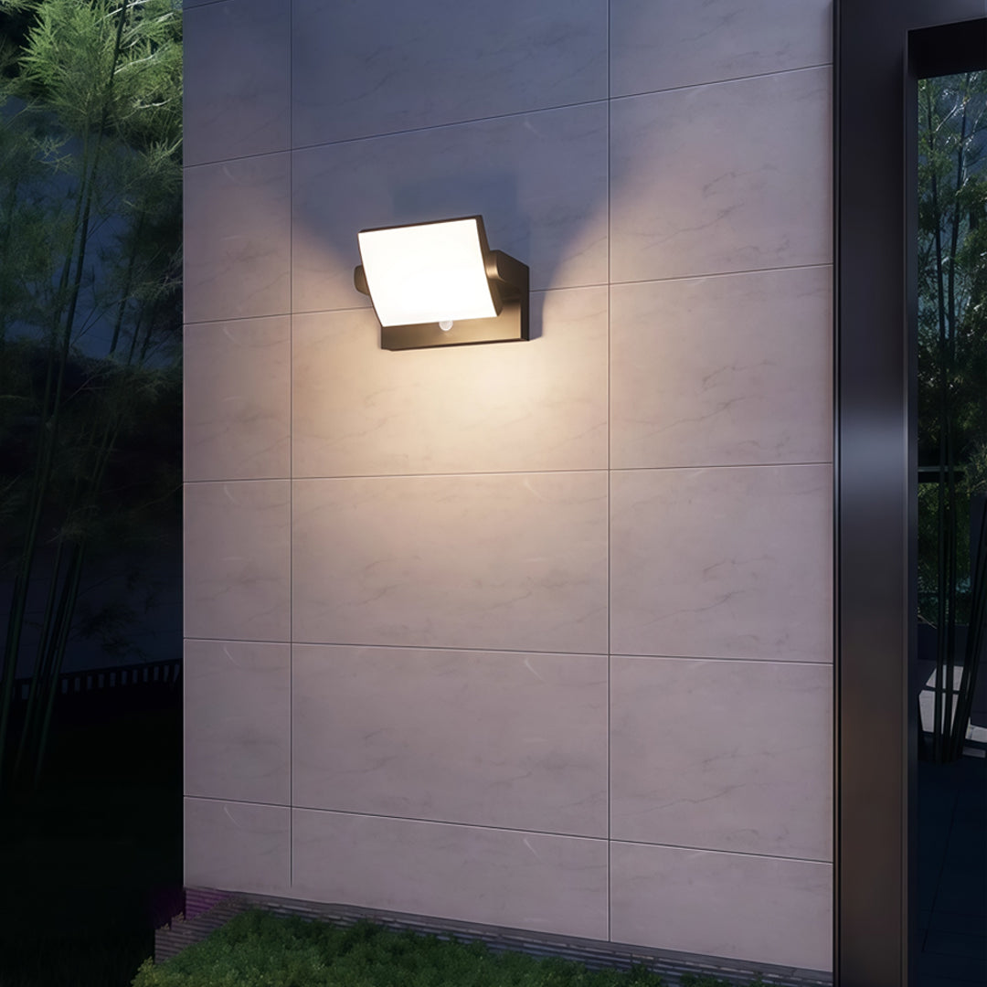 Warm-glow adjustable wall light illuminating a textured concrete wall in a contemporary setting.
