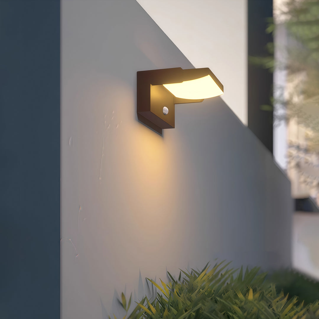 Modern adjustable wall light attached to a dark outdoor wall, enhancing pathway visibility.