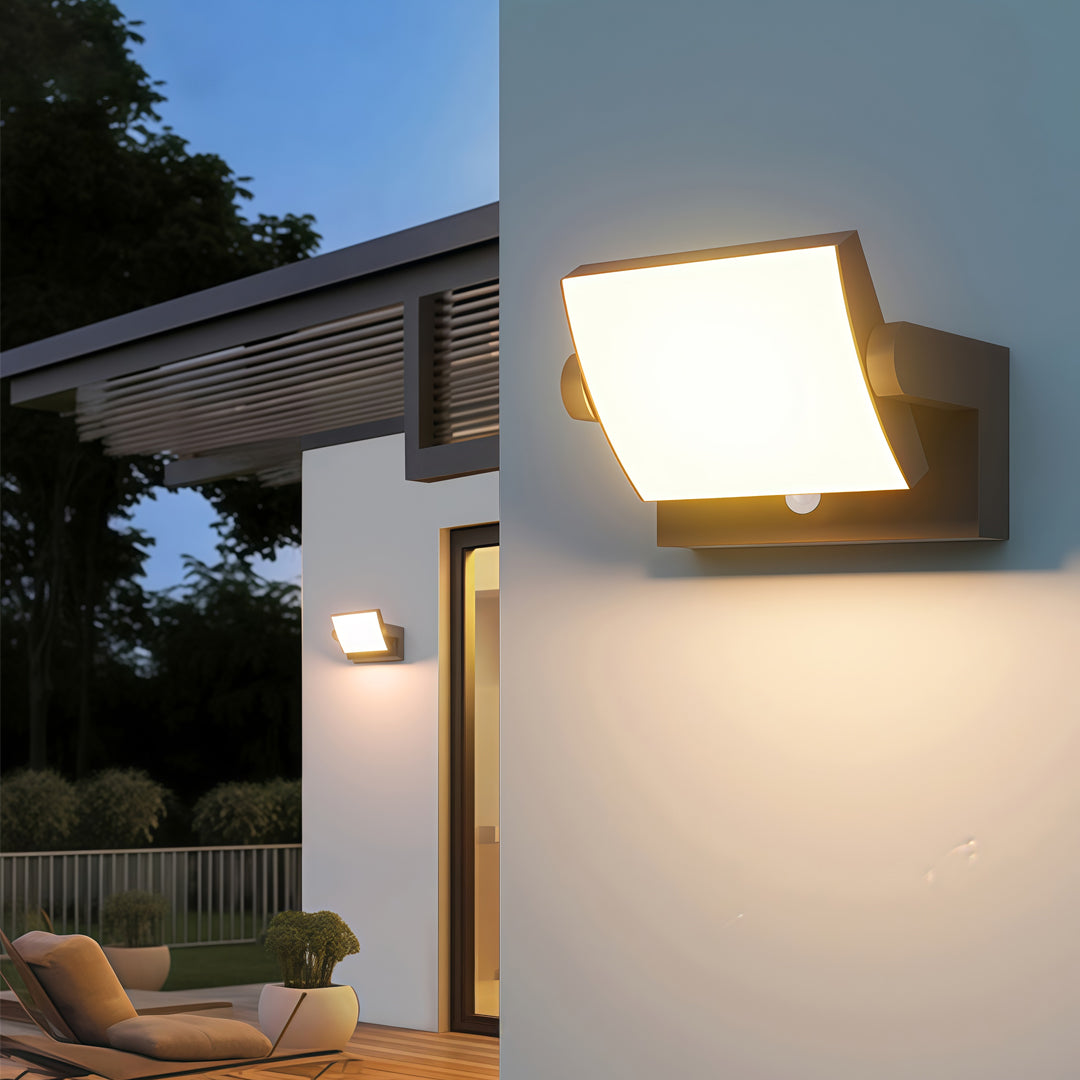 Adjustable wall light mounted on a white exterior wall, casting warm light over the entryway.