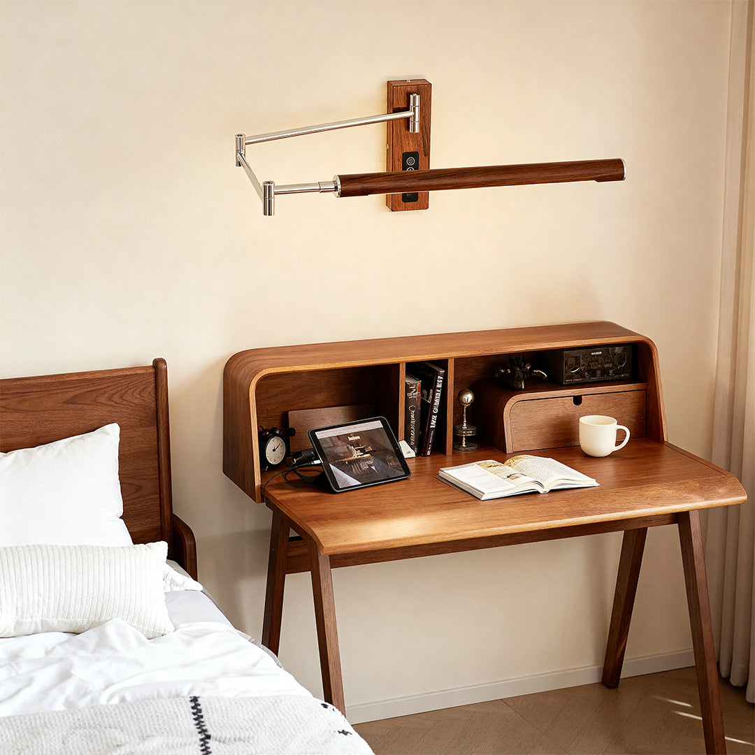 Adjustable wooden swing wall light mounted above a mid-century modern desk in a bedroom setting.