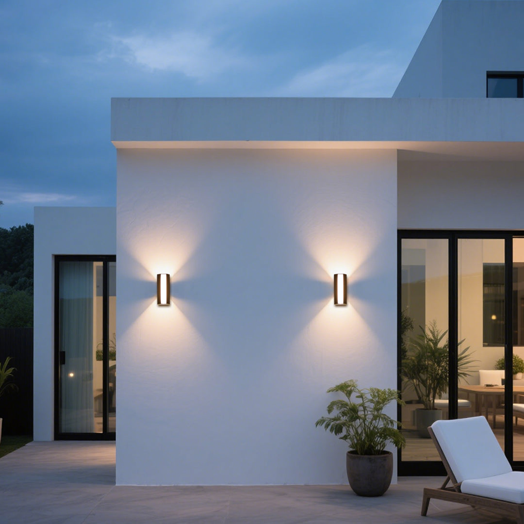 Vertical LED wall sconce mounted on textured stone exterior creating ambient lighting