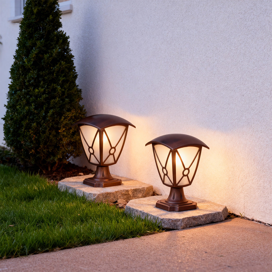 Two aluminum pillar light providing ambient illumination on pathway edge near manicured lawn at dusk