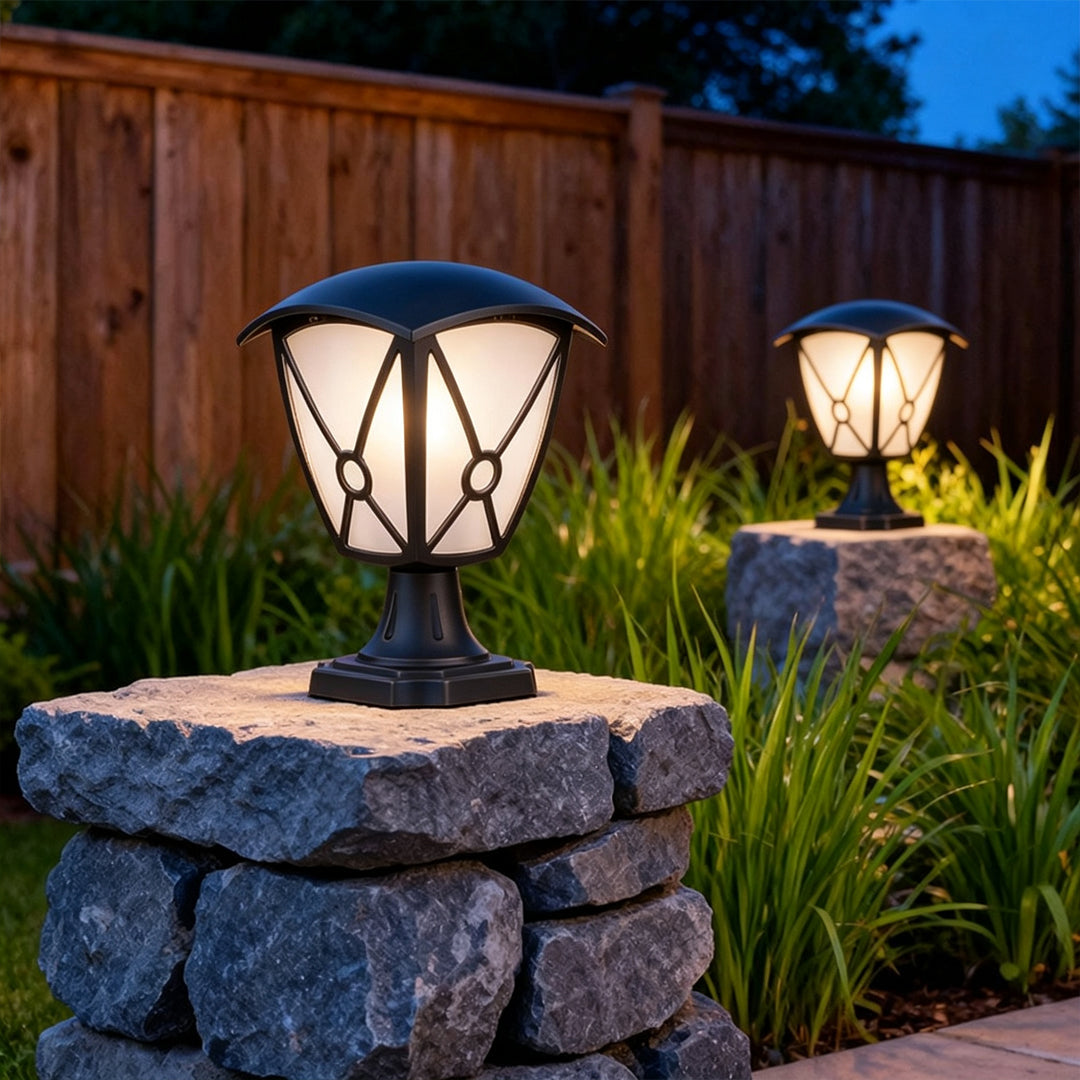 Aluminum pillar light installed on a stacked stone post beside a landscaped garden path.