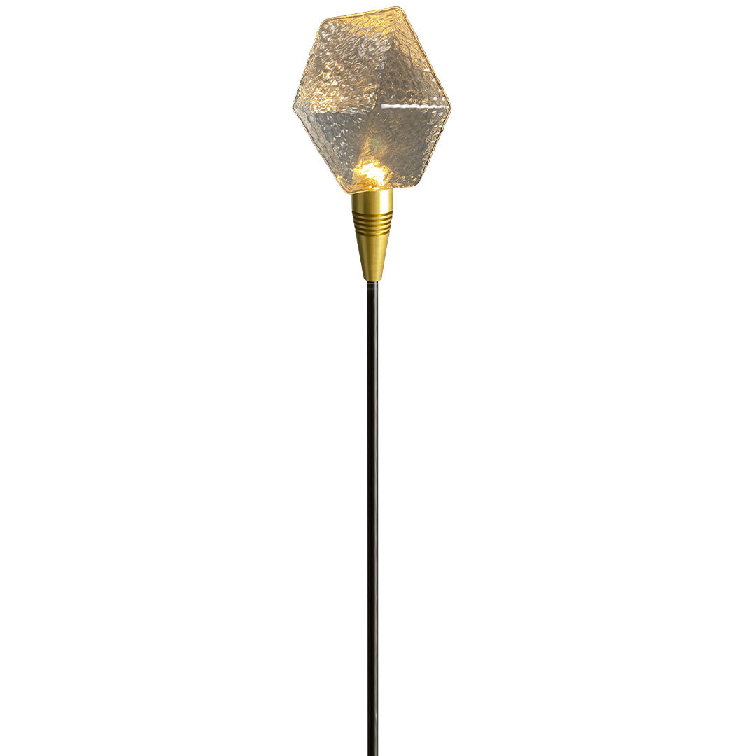 Amber globe garden stake illuminating outdoor plants, designed for scenic landscape lighting pathway.
