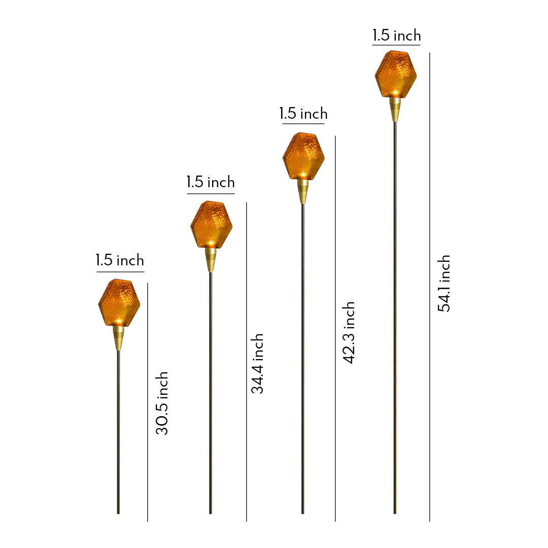 Warm amber globe stake illuminating a garden corner, designed as a decorative landscape lighting pathway accent.