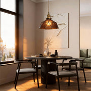 Amber indoor pendant light illuminating a modern dining area with warm, cozy glow. 