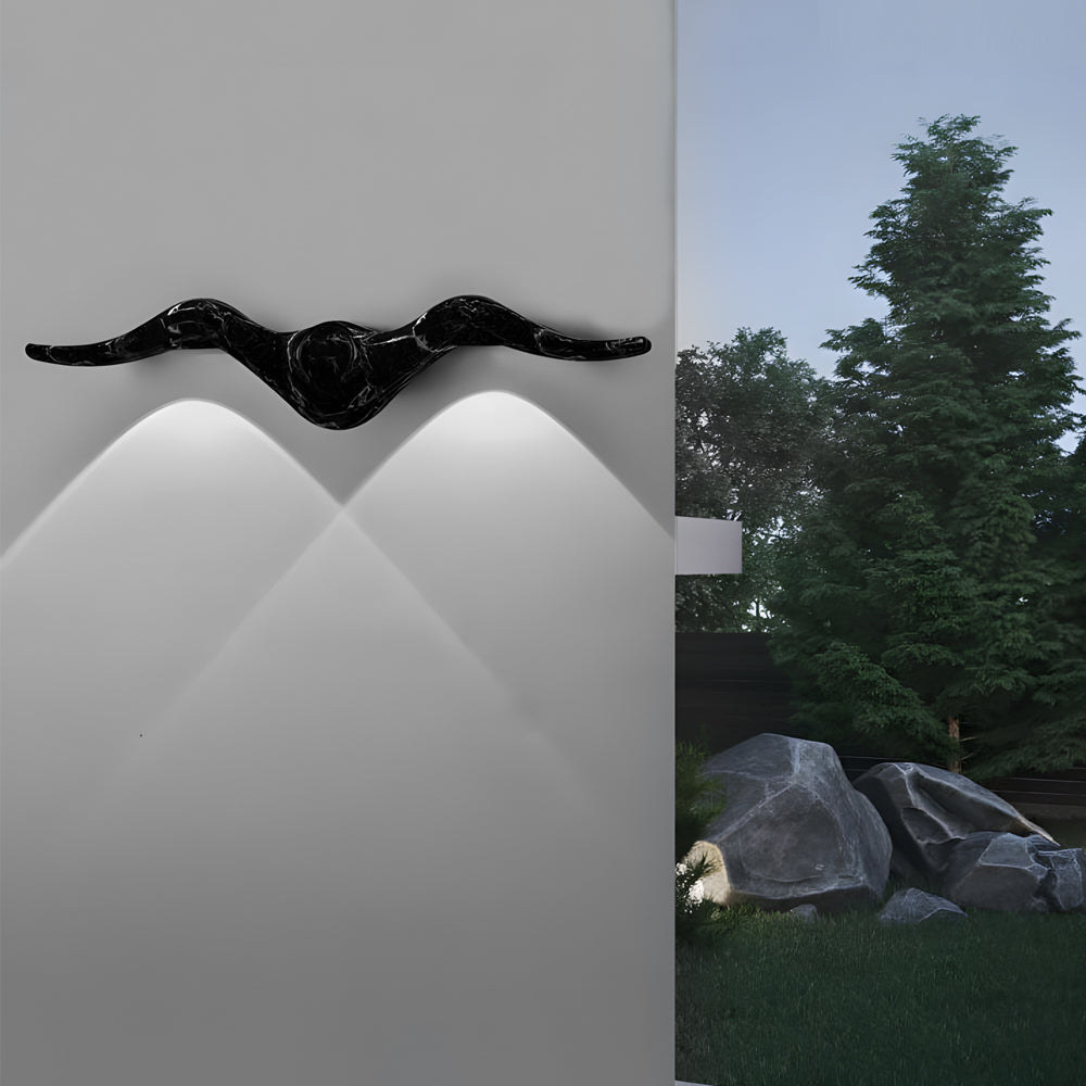 Black angular two light outdoor wall sconce mounted on exterior wall creating dramatic lighting effects