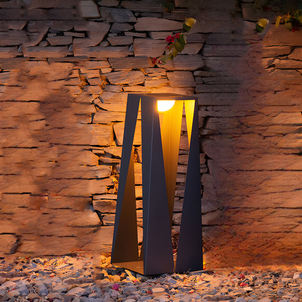 Modern angular landscape lighting flood lights with warm LED illumination creating dramatic accent lighting against natural stone wall